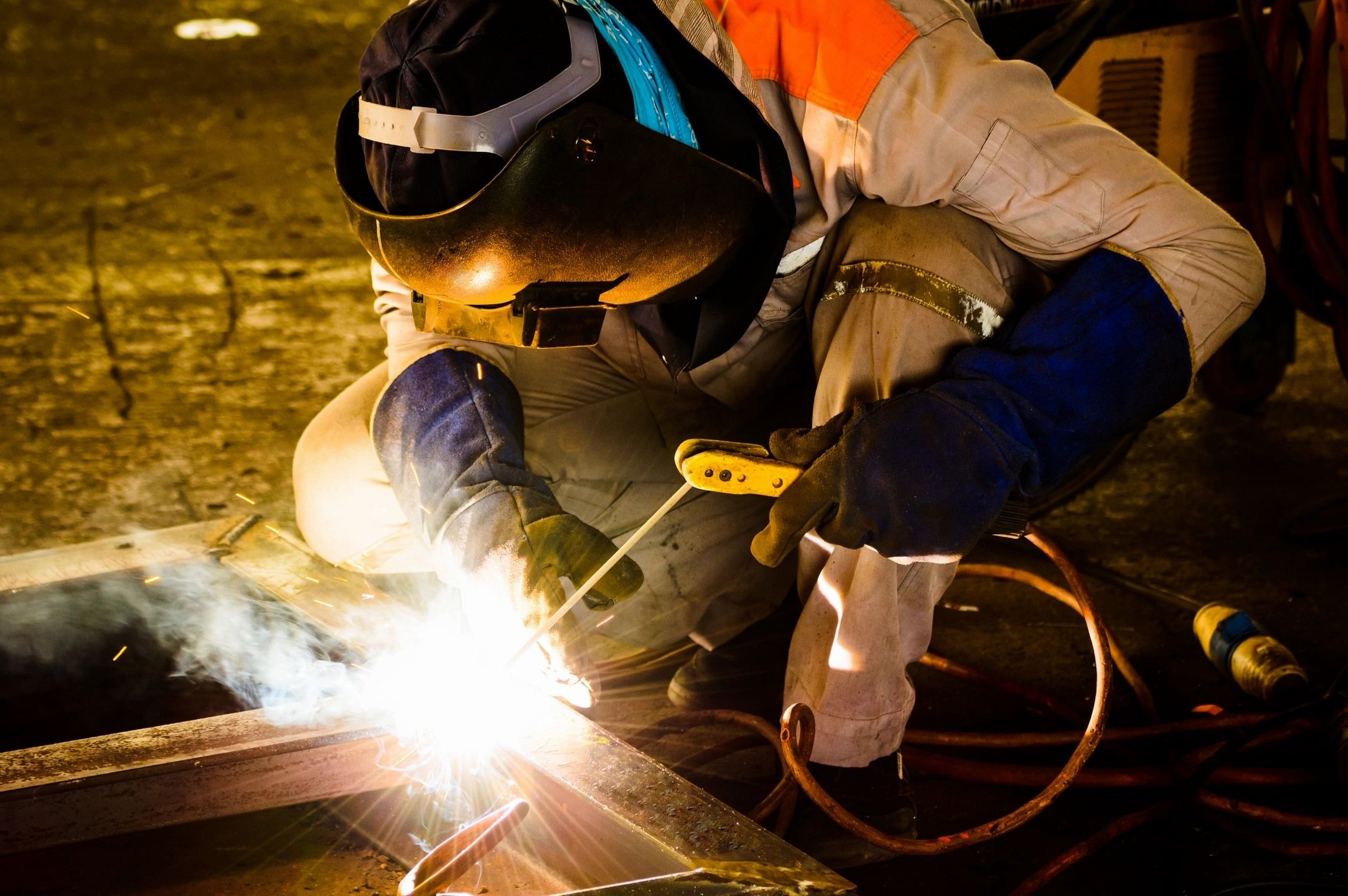 Welder working with arc welding torch