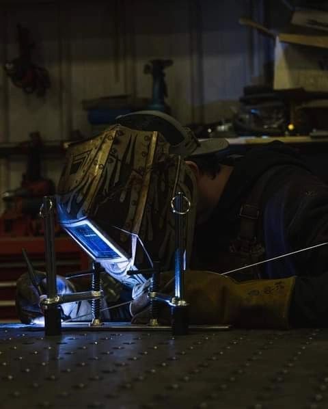 Welding metal parts in industrial workshop